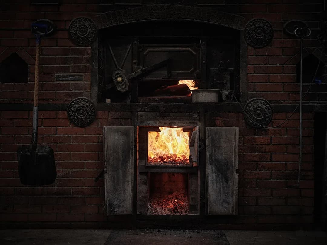 Flames and glowing embers in a time-worn brick bakery oven.
