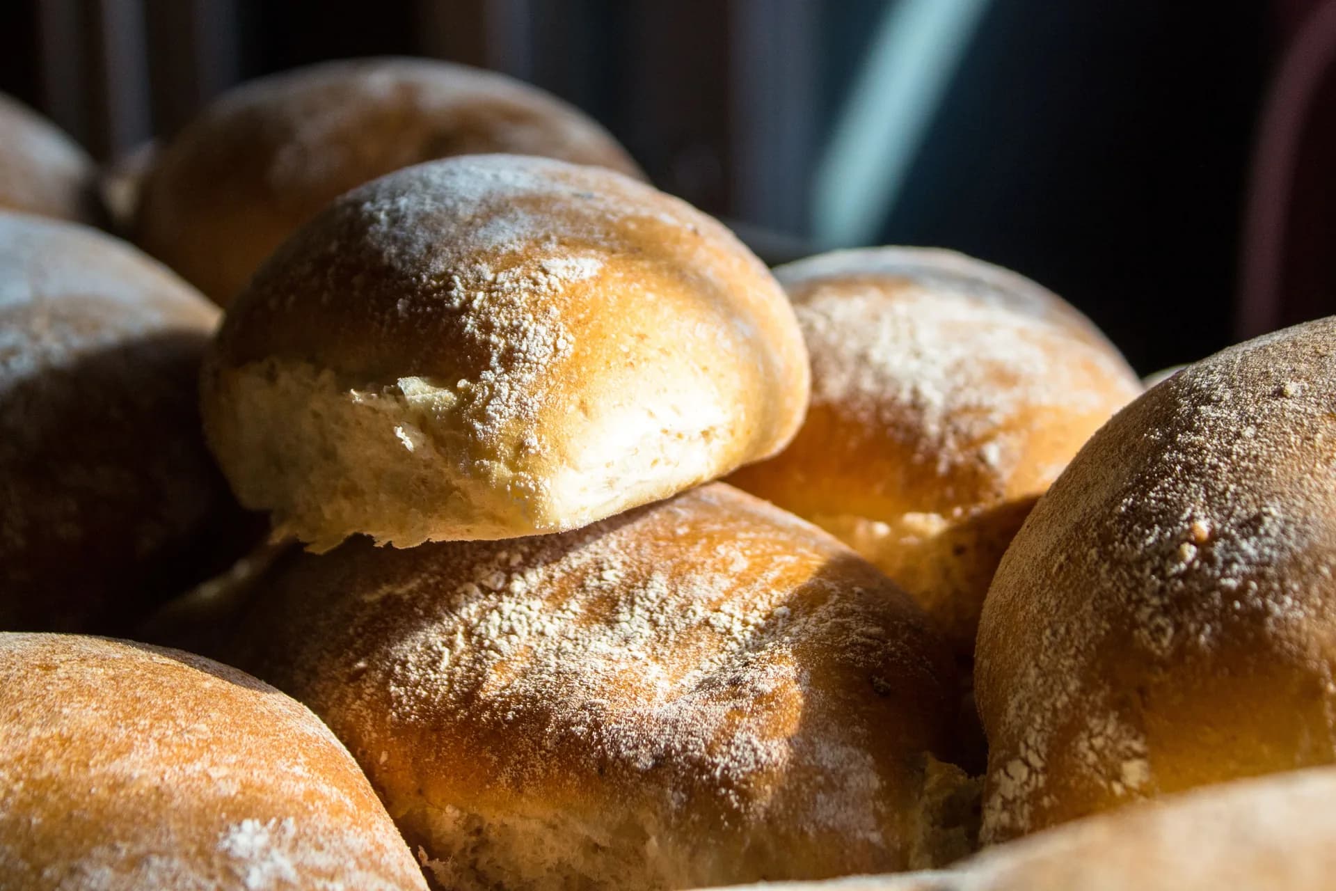 Golden, flour-dusted bread rolls resting together.